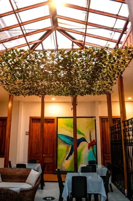 a room with tables and chairs and a painting at Casabella Hotel in Manizales