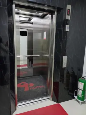 a metal elevator in a room with a red carpet at Hotel Granada Plaza in Manizales
