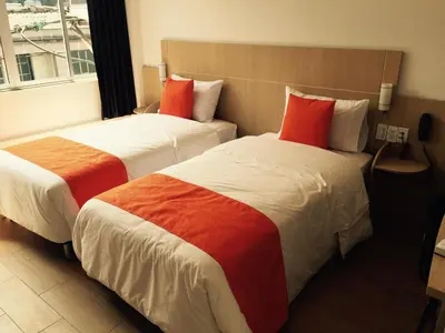 two beds in a hotel room with red pillows at Hotel Granada Plaza in Manizales