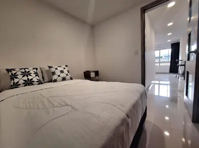 a bedroom with a large white bed with pillows at Hotel Granada Plaza in Manizales