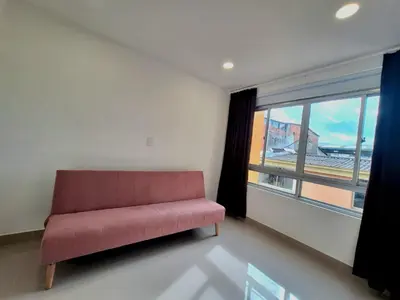 a red couch in a room with a large window at Hotel Granada Plaza in Manizales