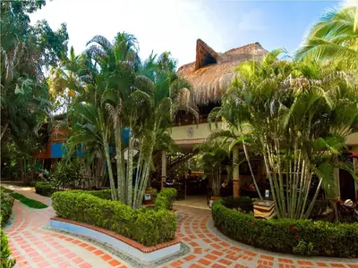 a resort with palm trees in front of a building at Hosteria Tonusco Campestre in Santa Fe de Antioquia