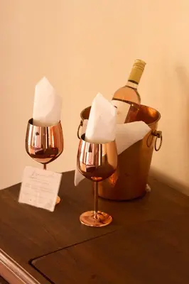 two lights on a table with a bottle of wine at Nueva Granada Hotel Colonial -Centro Histórico- in Santa Fe de Antioquia