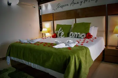 a bedroom with a bed with red flowers on it at Hotel Jade Spa in Santa Rosa de Cabal