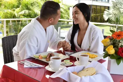 a man and a woman sitting at a table with food at Hotel Jade Spa in Santa Rosa de Cabal