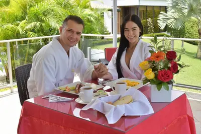 a man and a woman sitting at a table with food at Hotel Jade Spa in Santa Rosa de Cabal