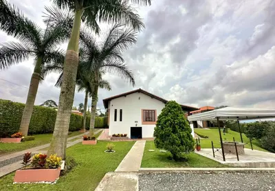a white house with palm trees in the yard at Hotel Jade Spa in Santa Rosa de Cabal