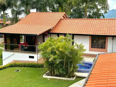a house with an orange roof and a palm tree at Hotel Jade Spa in Santa Rosa de Cabal
