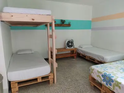 a room with two bunk beds and a fan at Hostal Paz y Vida in Medellín
