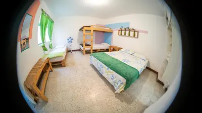 a small bedroom with a bed and a chair at Hostal Paz y Vida in Medellín