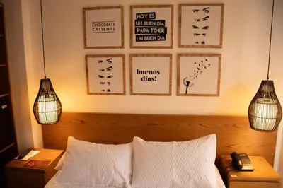 a bedroom with a bed with two pendant lights at Hotel Santamaria INN in La Ceja