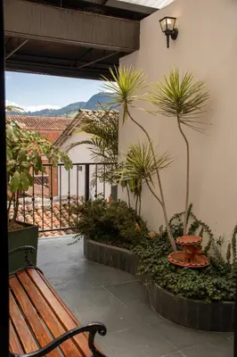 a bench sitting on a patio with palm trees at Hotel Santamaria INN in La Ceja