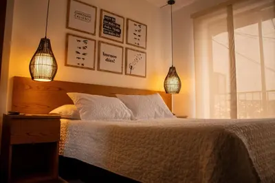 a bedroom with a bed with two lamps and a window at Hotel Santamaria INN in La Ceja