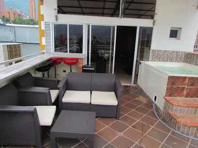 a balcony with a table and chairs and a hot tub at Apartamentos en el Poblado in Medellín