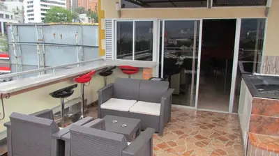 a balcony with chairs and a bar on a building at Apartamentos en el Poblado in Medellín