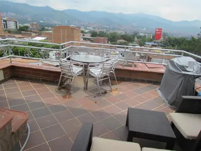 a patio with a table and chairs on a roof at Apartamentos en el Poblado in Medellín