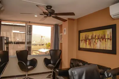 a waiting room with leather chairs and a window at Apartamentos en el Poblado in Medellín