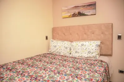 a bedroom with a bed with a floral bedspread at Apartamentos en el Poblado in Medellín