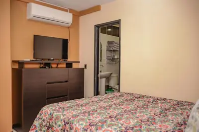 a hotel room with a bed and a flat screen tv at Apartamentos en el Poblado in Medellín