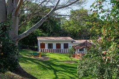 a small white house in the middle of a yard at Hotel Villa Camila in La Pintada