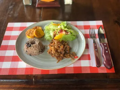a plate of food on a red and white table cloth at Hotel Villa Camila in La Pintada