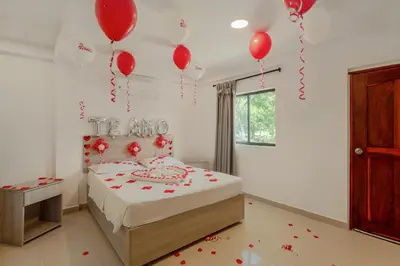 a bedroom with a bed with red balloons on the wall at Hotel Villa Camila in La Pintada