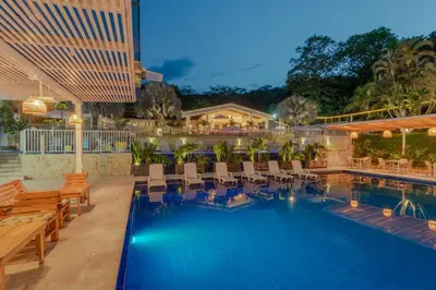 a hotel pool with chairs and a resort at Hotel Villa Camila in La Pintada