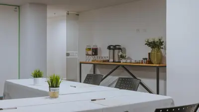 two tables and chairs in a room with white walls at Travelers Rio Verde Living Suites in Rionegro
