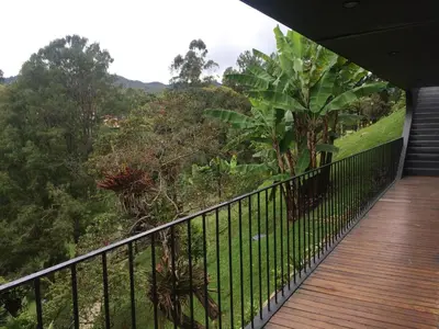a balcony with a view of a forest at Cabañas el Retorno in Guatapé