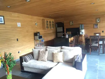 a living room with a white couch and a kitchen at Cabañas el Retorno in Guatapé