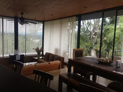 a living room with a table and a large window at Cabañas el Retorno in Guatapé