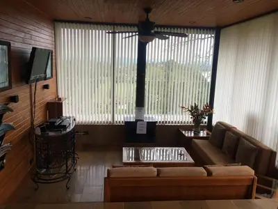 a living room with a couch and a large window at Cabañas el Retorno in Guatapé