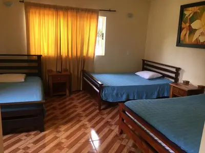 a bedroom with two beds and a wooden floor at Finca Hotel La Ponderosa in Rionegro