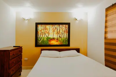 a bedroom with a bed and a painting on the wall at Finca Hotel La Ponderosa in Rionegro