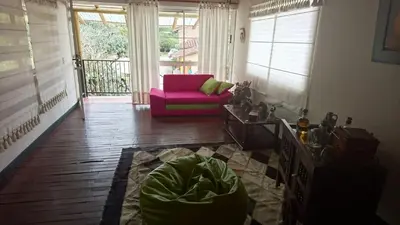 a living room with a pink chair and a couch at Finca Hotel La Ponderosa in Rionegro