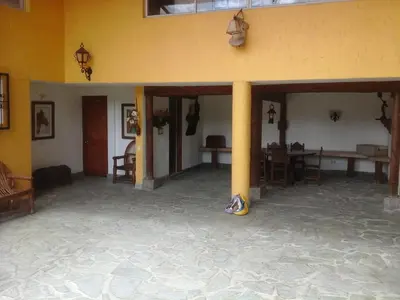 a large room with tables and chairs in a building at Finca Hotel La Ponderosa in Rionegro