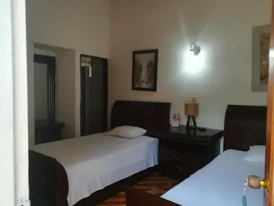 a bedroom with two beds and a desk with a lamp at Finca Hotel La Ponderosa in Rionegro