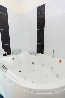 a white bath tub in a bathroom with black tiles at Hotel Verony Guatape in Guatapé