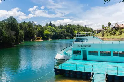 a boat is docked at a dock on a river at Hotel Verony Guatape in Guatapé