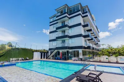 a hotel with a swimming pool and a building at Hotel Verony Guatape in Guatapé