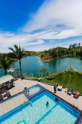 a large swimming pool with a view of a lake at Hotel Verony Guatape in Guatapé
