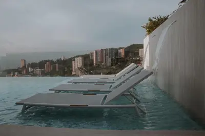 a row of lounge chairs sitting in the water at Binn Hotel in Medellín