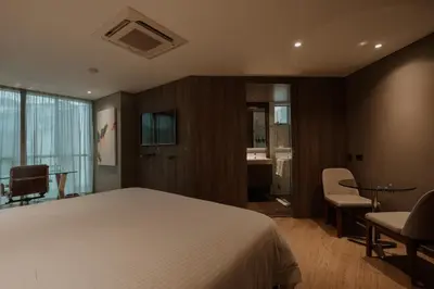 a bedroom with a bed and a table and chairs at Binn Hotel in Medellín