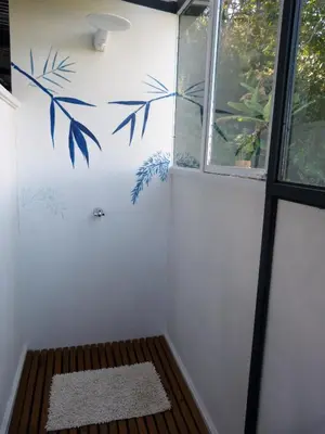 a bathroom with a wall with blue leaves painted on it at Casa Jade in Rionegro