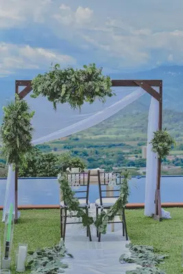 an outdoor ceremony with two chairs and an arch at Finca Hotel Villa Clara in Chinchiná