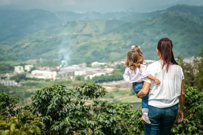 a woman holding a little girl standing on top of a mountain at Finca Hotel Villa Clara in Chinchiná