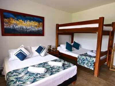 a bedroom with two bunk beds and a painting on the wall at Finca Hotel Villa Clara in Chinchiná