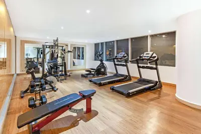 a gym with several treadmills and elliptical machines at La Quinta by Wyndham Medellin in Medellín