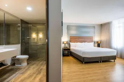 a hotel room with a bed and a bathroom at La Quinta by Wyndham Medellin in Medellín
