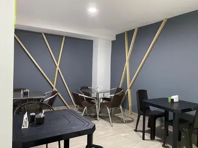 a dining room with tables and chairs and blue walls at Hotel Jardin de Laureles Jeps in Medellín